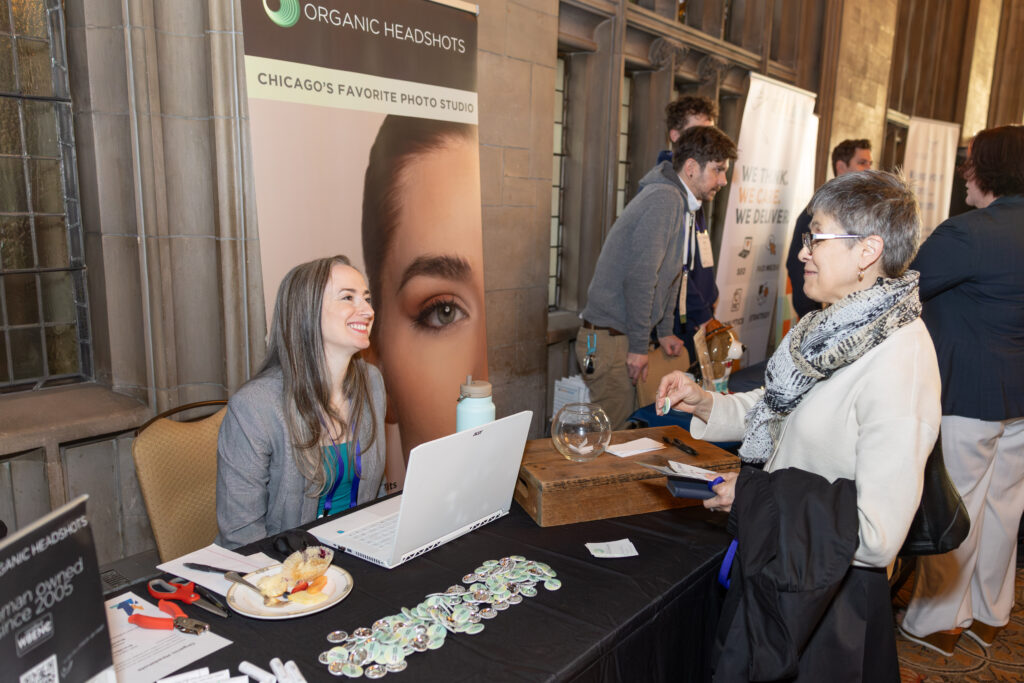 BrandSmart 2025 attendee speaking with one of the sponsors at a booth; both are smiling